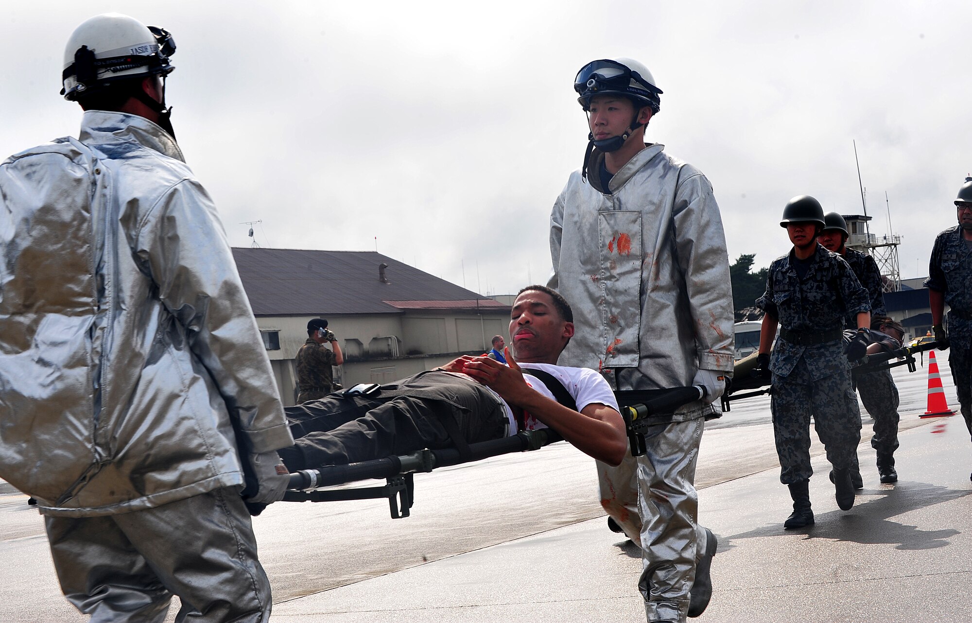 Japan Air Self-Defense Force firefighters carry U.S. Air Force Airman 1st Class Ian Segears, 610th Air Control Flight weapons director technician, on a litter to safety during a joint bilateral Major Accident Response Exercise at Misawa Air Base, Japan Aug. 22, 2014. JASDF and U.S. military emergency personnel worked to ensure all victims were moved away from the accident scene to safety. (U.S. Air Force photo by Senior Airman Jose L. Hernandez-Domitilo)