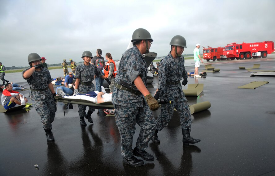 Members of the Japan Air Self-Defense Force move a simulated injured victim on a litter to safety during a joint bilateral Major Accident Response Exercise at Misawa Air Base, Japan Aug. 22, 2014. Both Japanese and American military emergency personnel responded to the scene and worked together to tend to injured victims. (U.S. Air Force photo by Senior Airman Jose L. Hernandez-Domitilo)