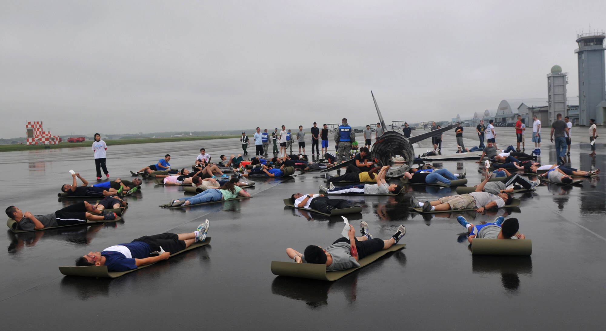 Airmen from the 35th Fighter Wing lay on the ground shortly before the start of a joint bilateral Major Accident Response Exercise at Misawa Air Base, Japan Aug. 22, 2014. These individuals were selected to play injured victims during this annual exercise. (U.S. Air Force photo by Senior Airman Jose L. Hernandez-Domitilo)