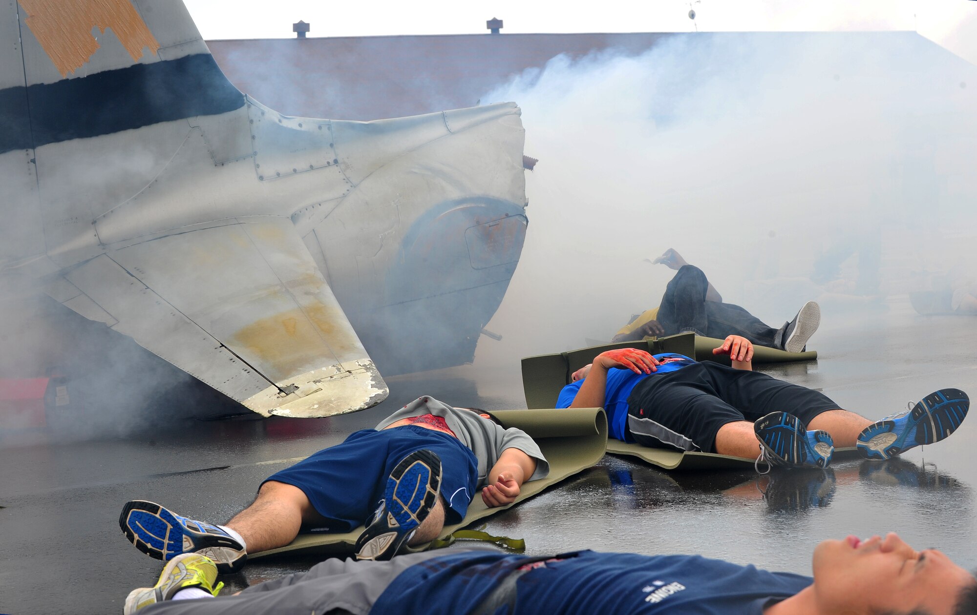 Simulated injured victims lay on the ground acting out their agony and pain during a joint bilateral Major Accident Response Exercise at Misawa Air Base, Japan Aug. 22, 2014. The victims were encouraged to add personal dramatic effect to enhance the realism of the exercise. (U.S. Air Force photo by Senior Airman Jose L. Hernandez-Domitilo)