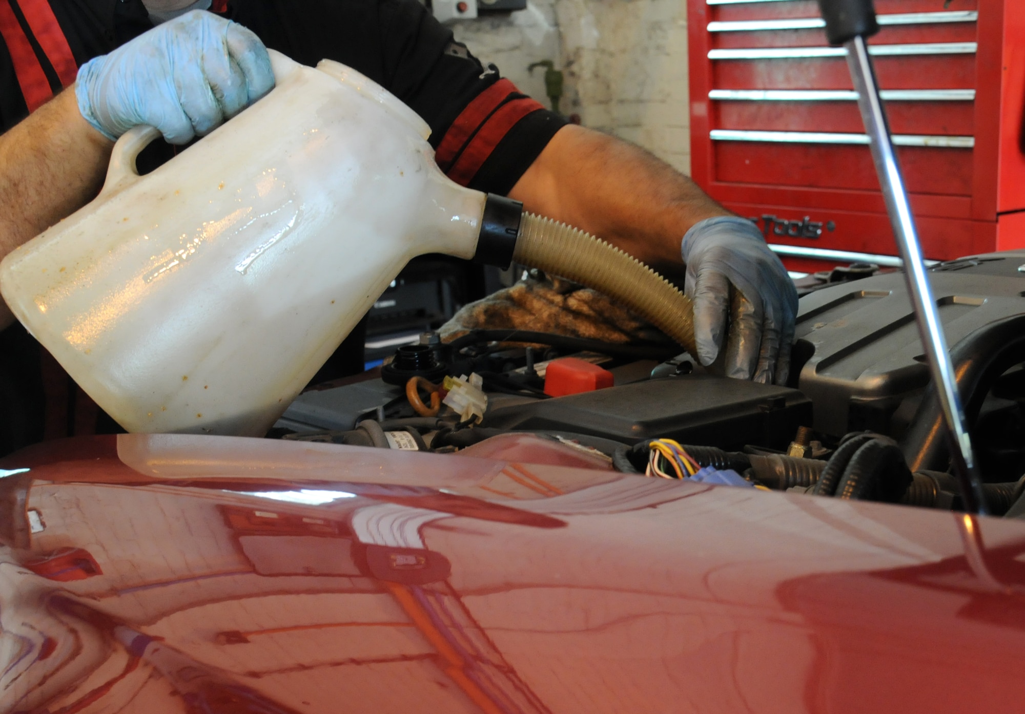 Alejandro Soto, 100th Force Support Squadron auto hobby shop technician from McFarland, Calif., funnels fresh oil into a vehicle’s oil tank Aug. 13, 2014, at the auto hobby shop on RAF Mildenhall, England. It’s very important to make regular oil changes in order to prolong the life of an engine, maintain the efficiency of the vehicle and control emissions. (U.S. Air Force photo/Gina Randall/Released)