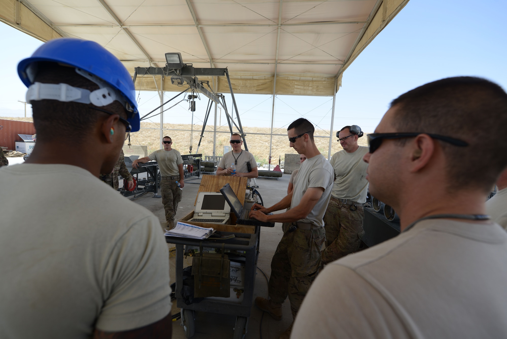 U.S. Air Force Airmen assigned to the 455th Expeditionary Maintenance Squadron gather together to review safety procedures before building 10 GBU-38 bombs at Bagram Airfield, Afghanistan Aug. 14, 2014. The GBU-38 is an essential part of the weapons system of an F-16C Fighting Falcon. The deployed Airmen are an example of total force integration; the airmen are comprised of active duty and reservists from Whiteman Air Force Base and Air National Guardsmen from Alabama and New Jersey. (U.S. Air Force photo by Master Sgt. Cohen A. Young/Released)