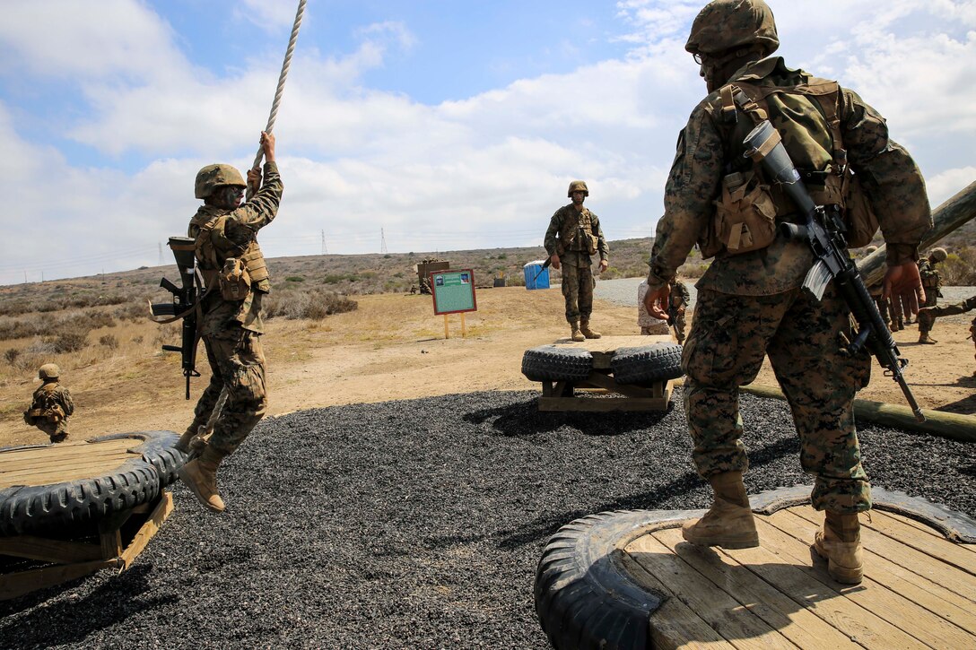 A recruit from Mike Company, 3rd Recruit Training Battalion, attempts to swing to a platform during Gonzalez’s Challenge at Marine Corps Base Camp Pendleton, Calif., Aug. 20. Touching the ground marked a simulated casualty and required the recruit to perform an exercise before returning to assist his fellow recruits.