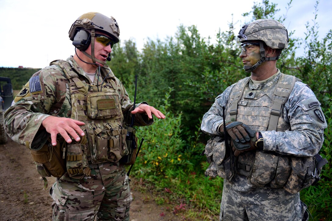 Air Force Lt. Col. J.B. Waltermire, left, and Army Lt. Col. James Hayes discuss tactics as soldiers and airmen train together to hone joint interoperability and close air support capabilities in a simulated combat environment during the Red Flag-Alaska 14-3 exercise on Yukon Training Area, Alaska, Aug. 20, 2014. Red Flag-Alaska is a series of Pacific Air Forces commander-directed exercises providing joint offensive counter-air, interdiction, close air support and large-force employment training. Waltermire is commander of the 140th Air Support Operations Squadron, and Hayes is commander of the 1st Cavalry Regiment, 1st Stryker Brigade Combat Team, Alaska. 