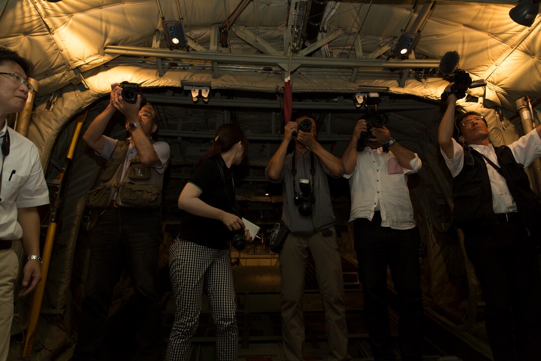 Iwakuni City Base Policy representatives document a KC-130J Super Hercules during a familiarization flight, Aug. 28, 2014, aboard Marine Corps Air Station Iwakuni, Japan. Along with the public affairs representatives, media and Government of Japan’s Ministry of Defense representatives flew aboard the C-130 to gain a better understanding of its capabilities.