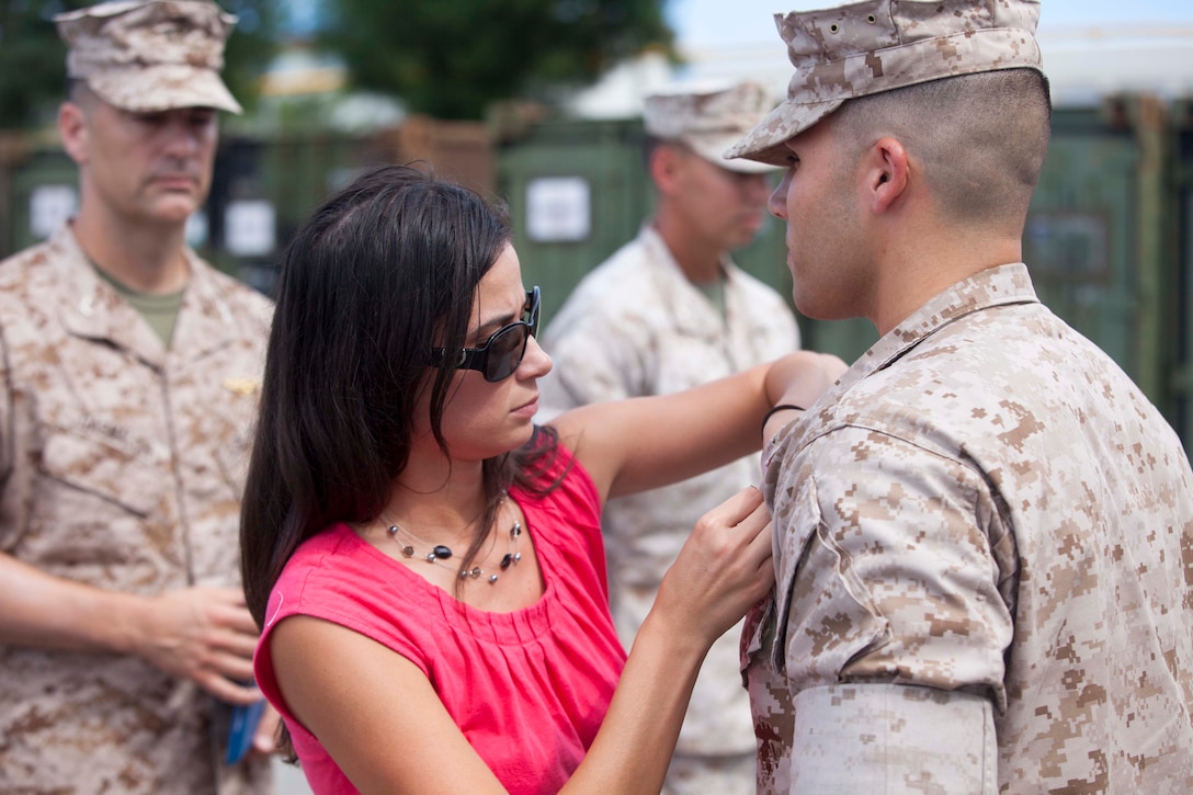 Mrs. Ariana Beltran pins the Fleet Marine Force Warfare insignia on her husband, Navy Lt. Manuel H. Beltran on Camp Hansen, Okinawa, Japan August 29. Lieutenant Beltran is the medical planner for the 31st Marine Expeditionary Unit and he and his wife are both natives of Elgin, Illinois. The FMF Qualified Officer Insignia is presented to U.S. Navy officers who complete all necessary requirements such as serving in a Marine Corps command for a year, completing an oral board held by FMF qualified officers, and passing a written test and the Marine Corps Physical Fitness Test. (U.S. Marine Corps photo by Staff Sgt. Joseph DiGirolamo)