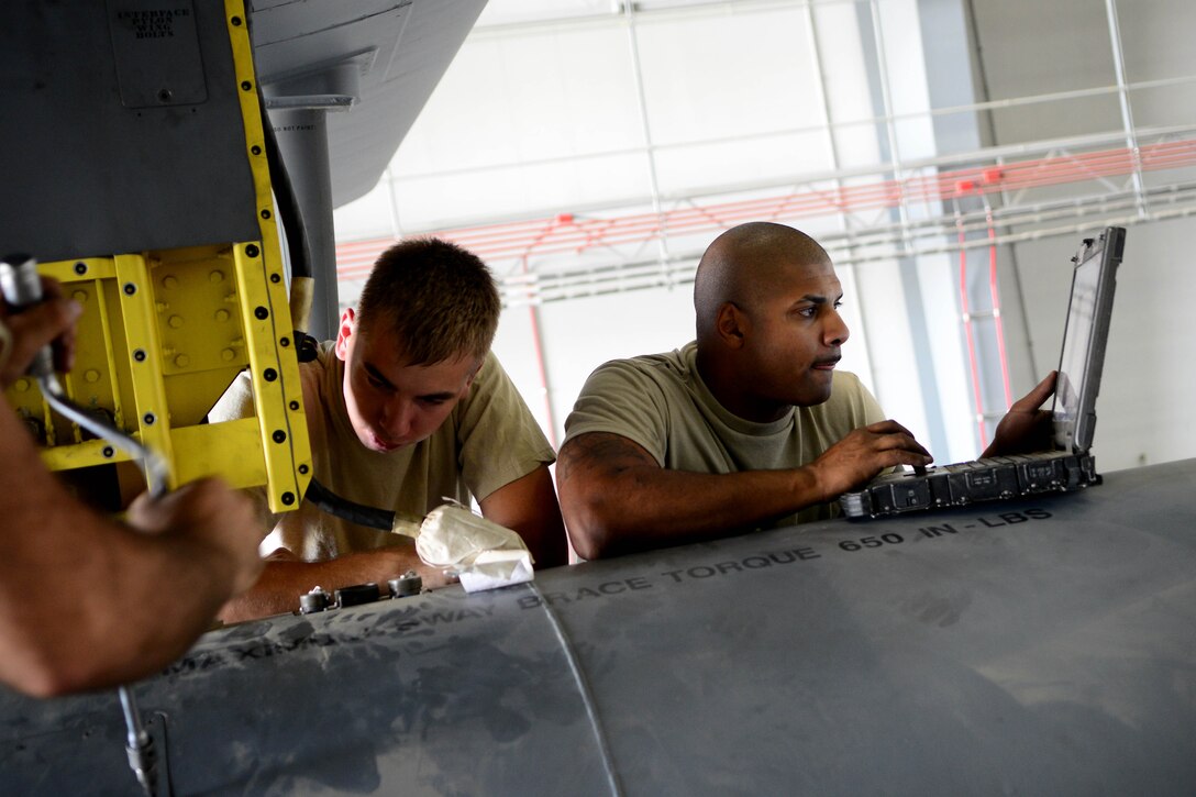 Senior Airman Jessie Mechling,  (left) electronic warfare systems journeyman, and Tech. Sgt. Daniel Schultz, electronic warfare systems craftsman, review technical order instructions at Bagram Airfield, Afghanistan Aug. 25, 2014. The Airmen are assigned to the 41st Expeditionary Electronic Combat Squadron, deployed from Davis-Monthan Air Force Base, Ariz.  The unit flies the EC-130H Compass Call aircraft whose primary mission is disruption of enemy command and control communications and to limit adversary coordination essential for enemy force management. (U.S. Air Force photo/Staff Sgt. Evelyn Chavez)