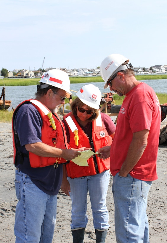USACE Project Manager Monica Chasten (middle) discusses dredging and placement operations with USACE Inspector Charlie Yates (left) and Joe Hill (right), owner of Barnegat Bay Dredging Company. The U.S. Army Corps of Engineers has partnered with the state of New Jersey and several non-profit organizations on a dredging and marsh restoration project along the New Jersey Intracoastal Waterway. The demonstration project involves dredging critical shoals from the waterway and restoring ecological habitat.  