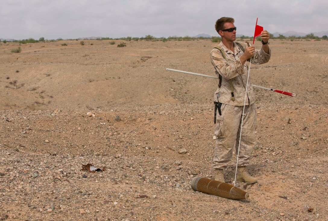 Staff Sgt. Kyle Winjum, an Explosive Ordnance Disposal technician with Marine Wing Support Squadron 372 from Marine Corps Base Camp Pendleton, Calif., flags and GPS marks unexploded ordnance during range clearance operations at the Chocolate Mountain Aerial Gunnery Range, Calif., Monday, Aug. 25, 2014.