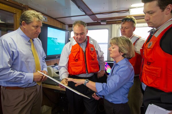 NORFOLK, Va. -- Bill Cofer (left), president of the Virginia Pilots Association, and Betty Grey Waring, Norfolk District operations branch chief, brief Sen. Tim Kaine about the status of the Hampton Roads federal navigation channel here Aug. 28, 2014. The senator also toured the district’s Craney Island Dredged Material Management Area and received a briefing on the status of its eastward expansion and how Craney benefits the local economy.  (U.S. Army photo/Patrick Bloodgood)