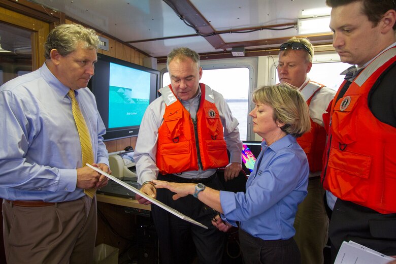 NORFOLK, Va. -- Bill Cofer (left), president of the Virginia Pilots Association, and Betty Grey Waring, Norfolk District operations branch chief, brief Sen. Tim Kaine about the status of the Hampton Roads federal navigation channel here Aug. 28, 2014. The senator also toured the district’s Craney Island Dredged Material Management Area and received a briefing on the status of its eastward expansion and how Craney benefits the local economy.  (U.S. Army photo/Patrick Bloodgood)