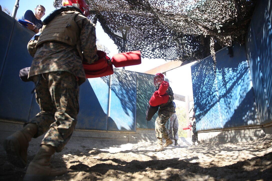 Recruits of Kilo Company, 3rd Recruit Training Battalion, run to the center to begin their bout during Pugil Sticks III at Marine Corps Recruit Depot San Diego, Aug. 26. Gear such as a helmet, groin protector, flak jacket and mouth piece was given to each recruit before entering.