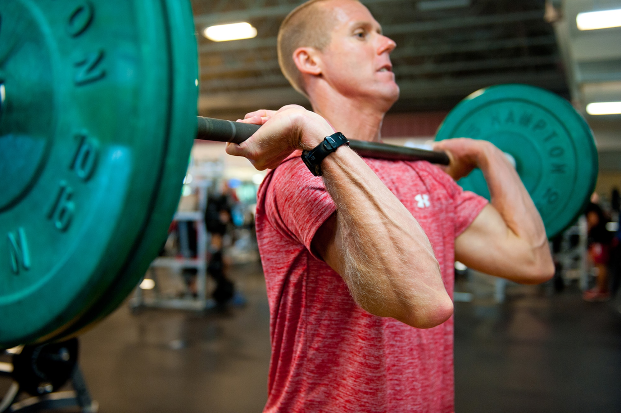 U.S. Air Force Lt. Col. Stephen Frank, instructor pilot, 559 Flying Training Squadron, does squats followed by a military press, 16 July, 2014, Joint Base San Antonio-Randolph, Texas. (U.S. Air Force photo by Tech. Sgt. Sarayuth Pinthong/ Released)