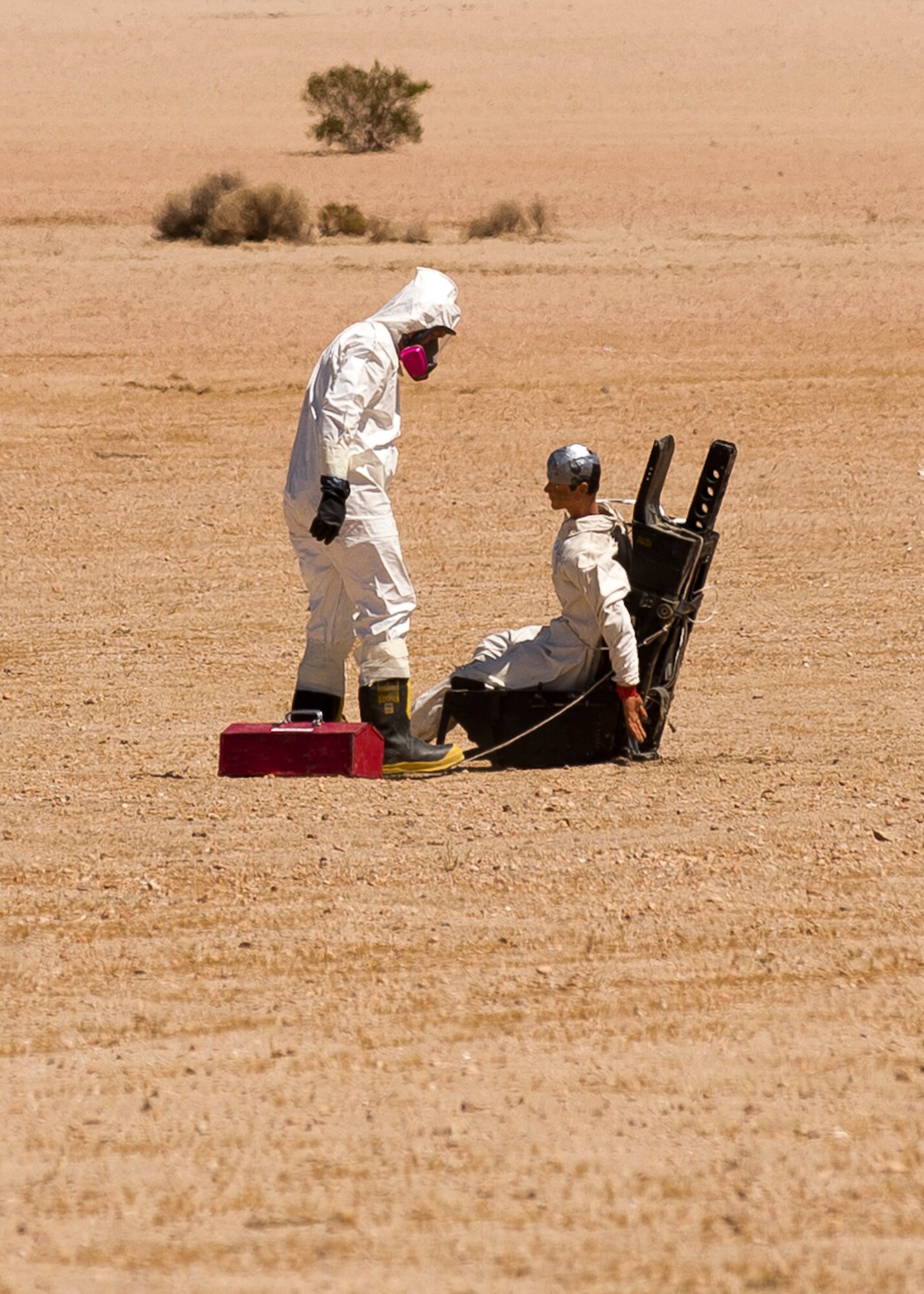 A member of Edward AFB's Explosive Ordnance Disposal team examines the "downed pilot" while determining the proper egress procedures to remove the pilot from the ejection seat. (U.S. Air Force photo by Ethan Wagner)
