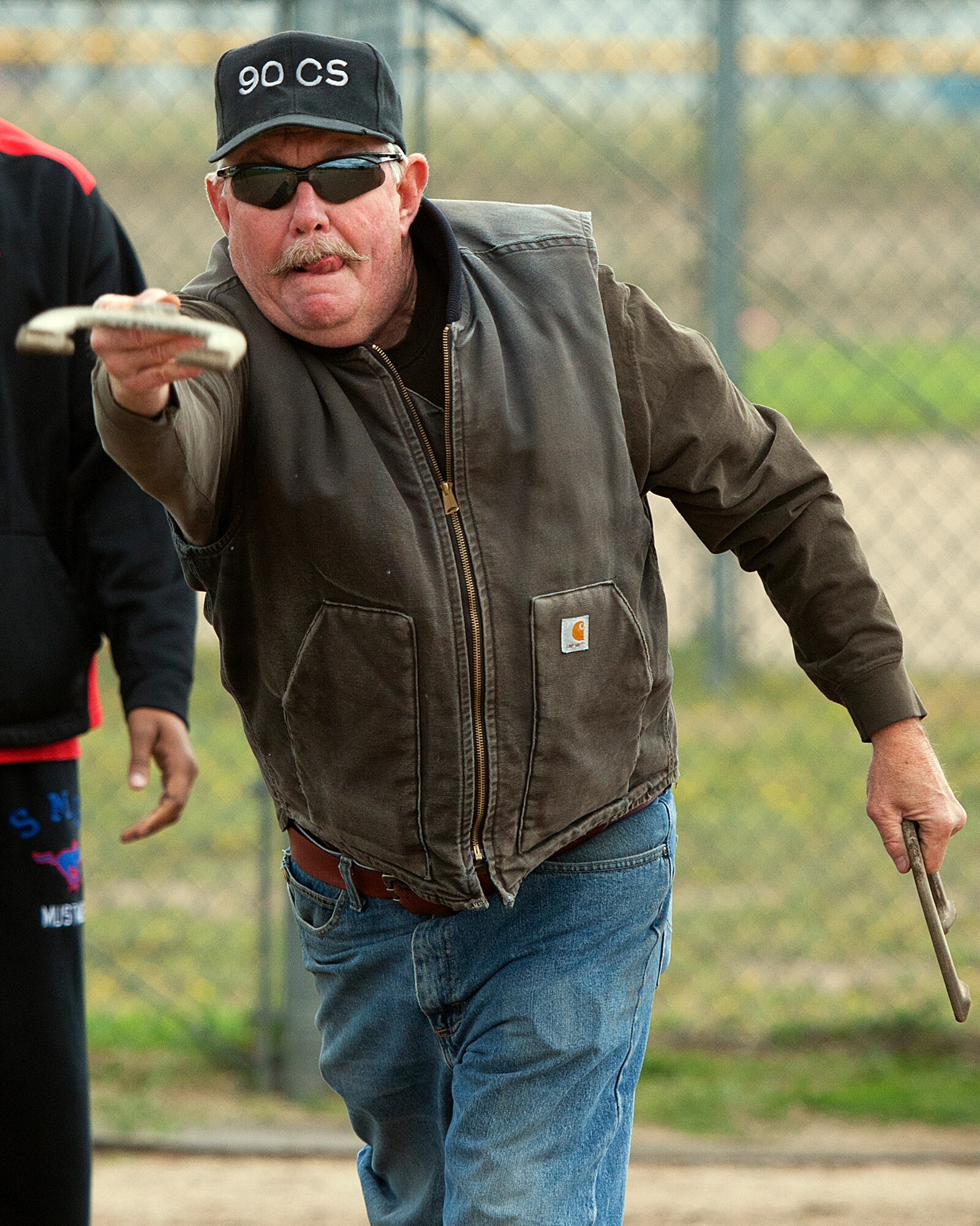 Mike Doan, 90th Communications Squadron Communication Focal Point, sends a horseshoe on its way during the  horseshoe toss competition at the 90th Missile Wing annual Frontiercade on F.E. Warren Air Force Base, Wyo., August 28, 2014. The picnic and squadron sports competition included volleyball, tug of war and other activities—as well as free food—for the 90 MW Airmen. (U.S. Air Force photo by R.J. Oriez/Released)