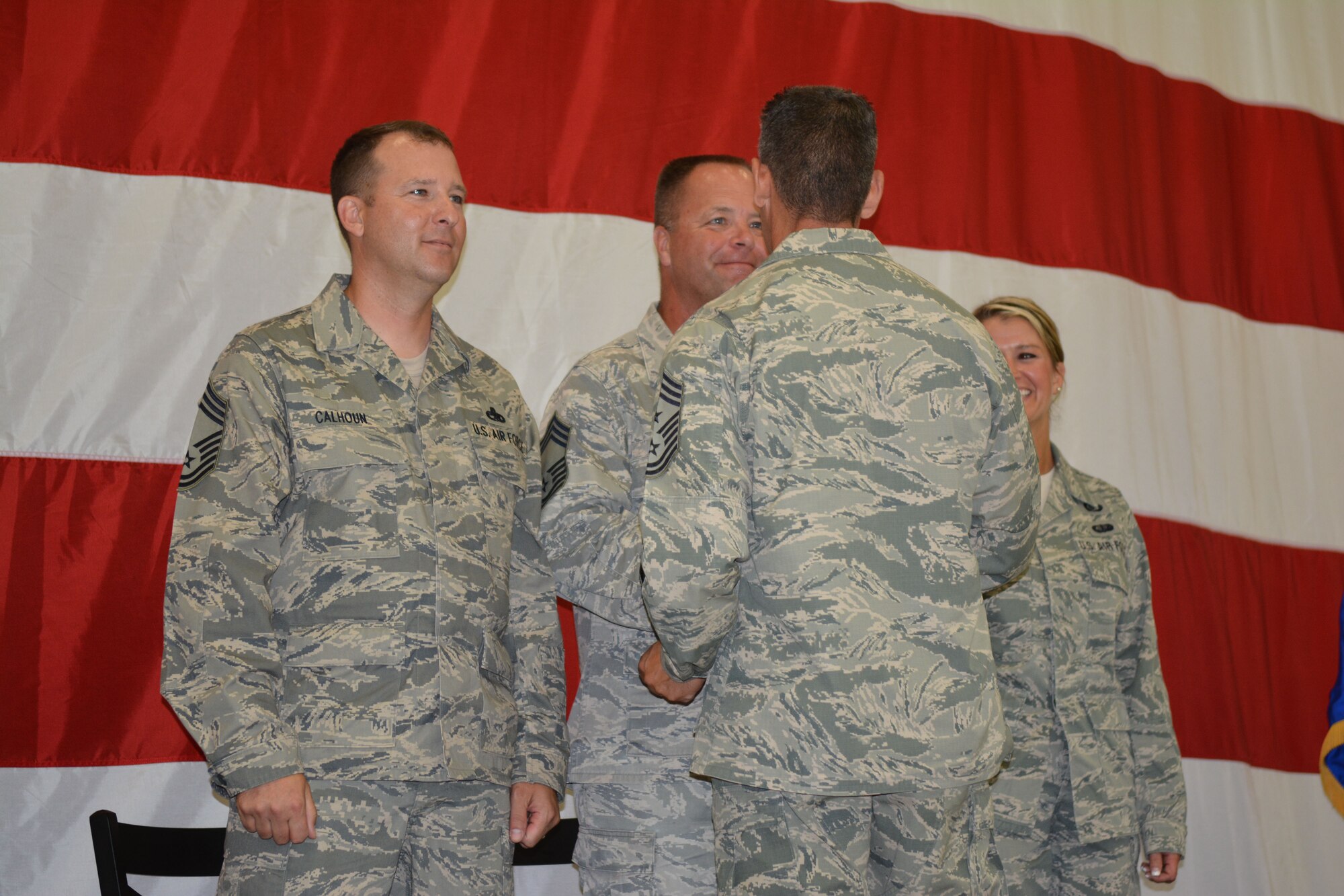 Chief Master Sgt. Thomas Safer, 115th Fighter Wing command chief, presents a state chief coin to each of the new 115 FW chiefs during their promotion recognition ceremony at Hangar 406 in Madison, Wis., Aug. 23, 2014. Only 2 percent of the Airmen in the Air National Guard can obtain the rank of chief master sergeant. (Air National Guard photo by Senior Airman Andrea F. Liechti)