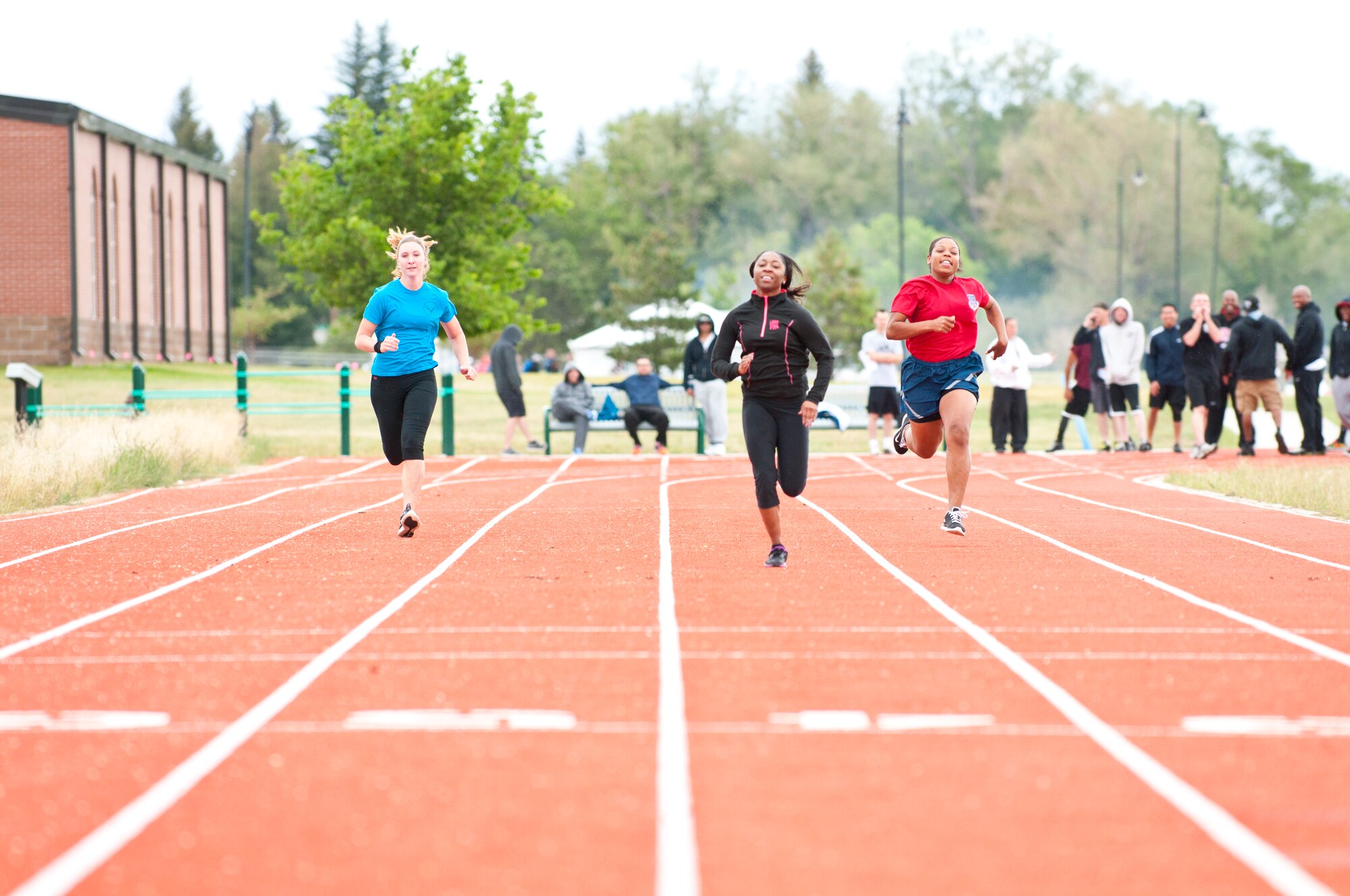 From left to right, 2nd Lt. Melissa Hawks, 90th Civil Engineer Squadron, Airman 1st Class Darlinda Wright, 90th Logistics Readiness Squadron, and Airman 1st Class Lakeesha Porter, 90th Medical Operations Squadron, compete in the women’s 100 meter race during Frontiercade on F.E. Warren Air Force Base, Wyo., Aug. 28, 2014. Frontiercade is an annual event comprised of various team competitions to foster camaraderie and friendly competition amongst the units of 90th Missile Wing. (U.S. Air Force photo by Lan Kim)