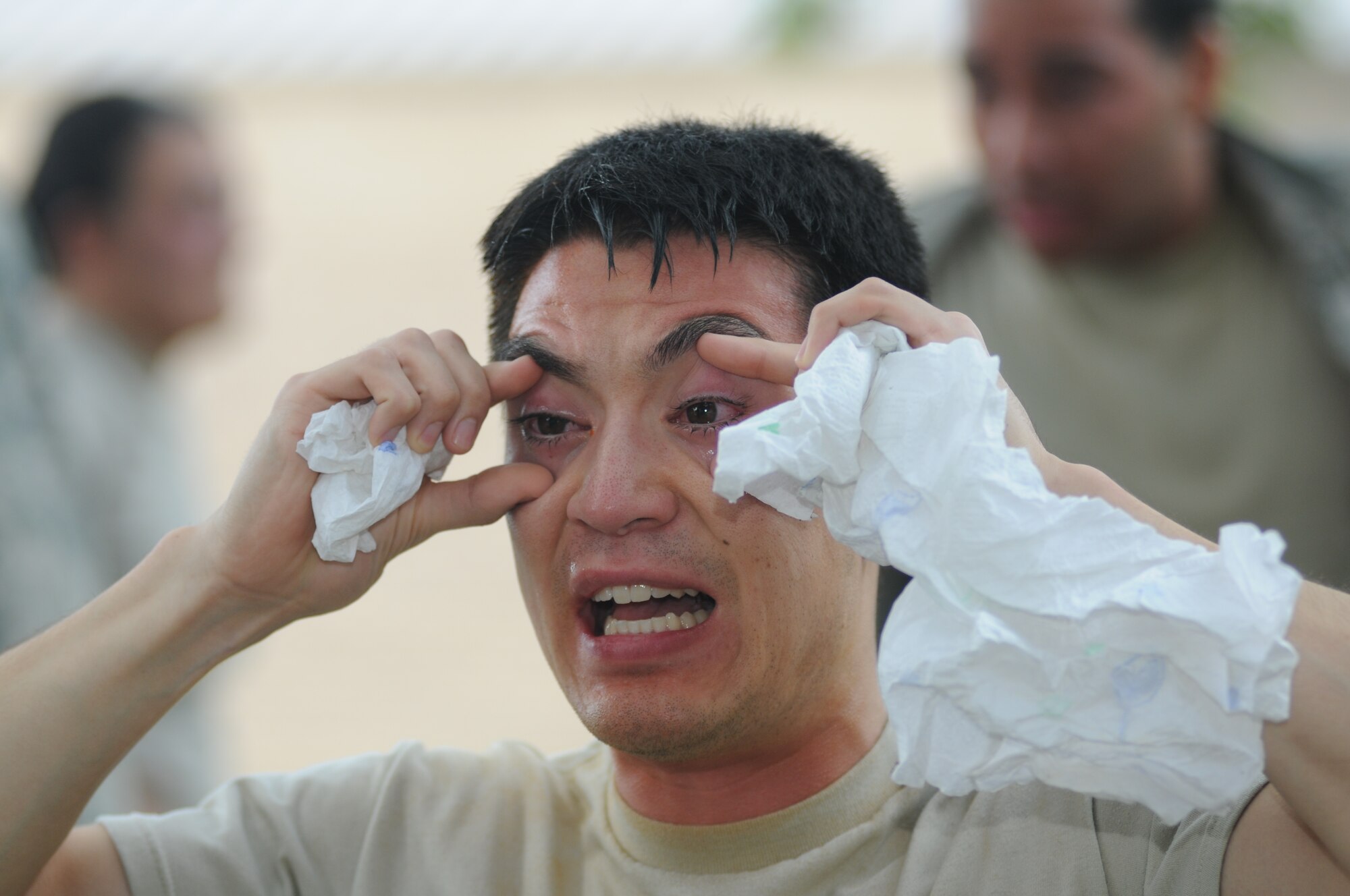 Senior Airman Sean Grametbauer, 81st Security Forces Squadron augmentee, reacts after being exposed with oleoresin capsaicin spray during OC spray training Aug. 28, 2014, at Keesler Air Force Base, Miss.  The training is a required one-time exposure of the OC spray for all Security Forces members.  (U.S. Air Force photo by Kemberly Groue)