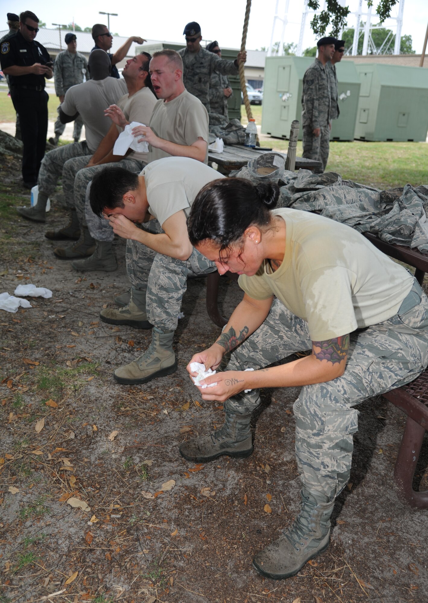 Staff Sgt. Eva Williams, 81st Security Forces Squadron augmentee, along with other 81st SFS augmentees react after being exposed with oleoresin capsaicin spray during OC spray training Aug. 28, 2014, at Keesler Air Force Base, Miss.  The training is a required one-time exposure of the OC spray for all Security Forces members.  (U.S. Air Force photo by Kemberly Groue)