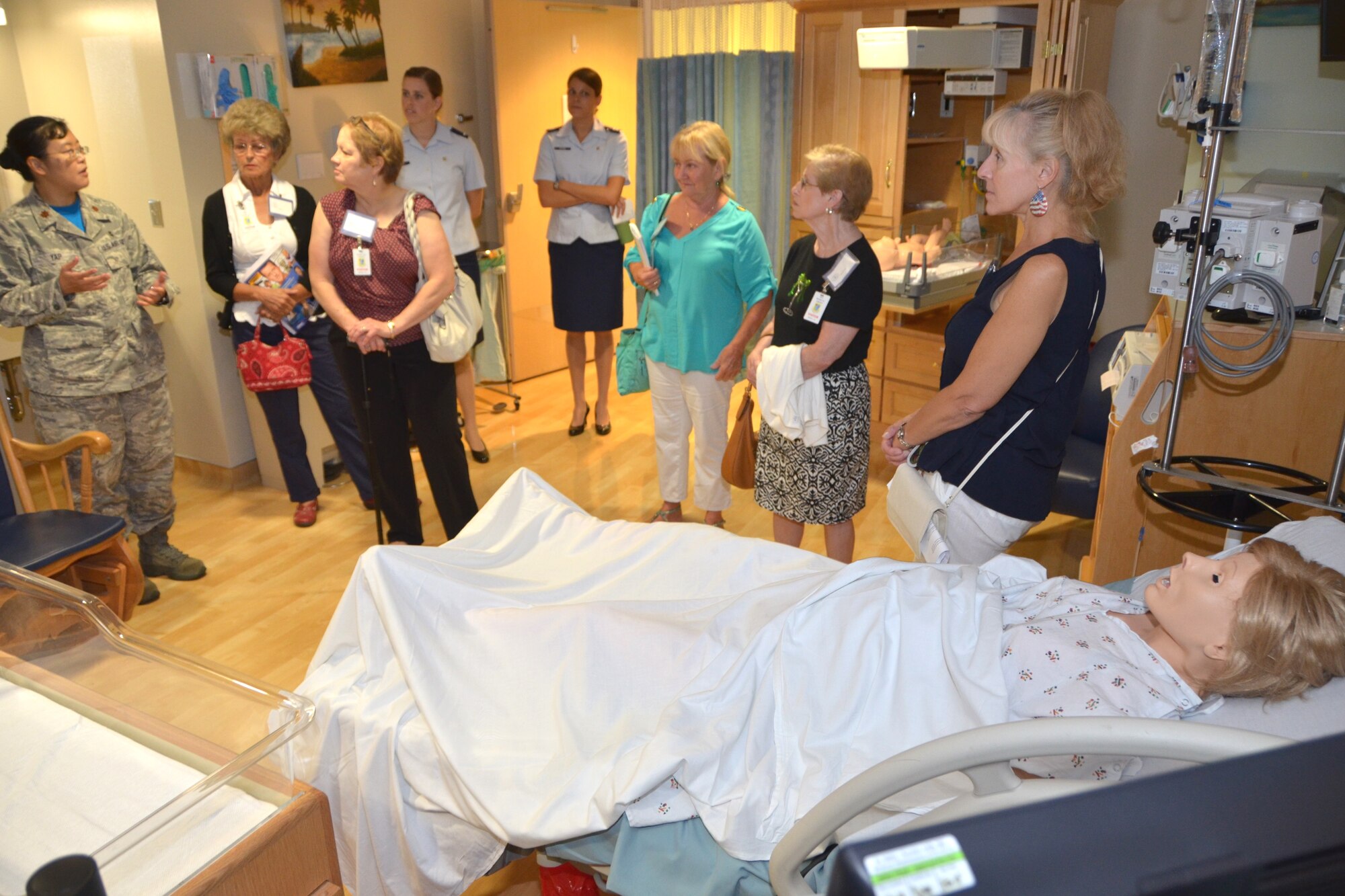 Maj. Cynthia Yap, 81st Inpatient Operations Squadron Maternal Child Flight commander, left, describes how obstetric patient simulator “Katrina” is used to train the flight staff in one of the unit’s labor, delivery, recovery and post-partum rooms during the Aug. 22, 2014 Air Force Society of Retired Nurses visit. (U.S. Air Force photo by Steve Pinick)