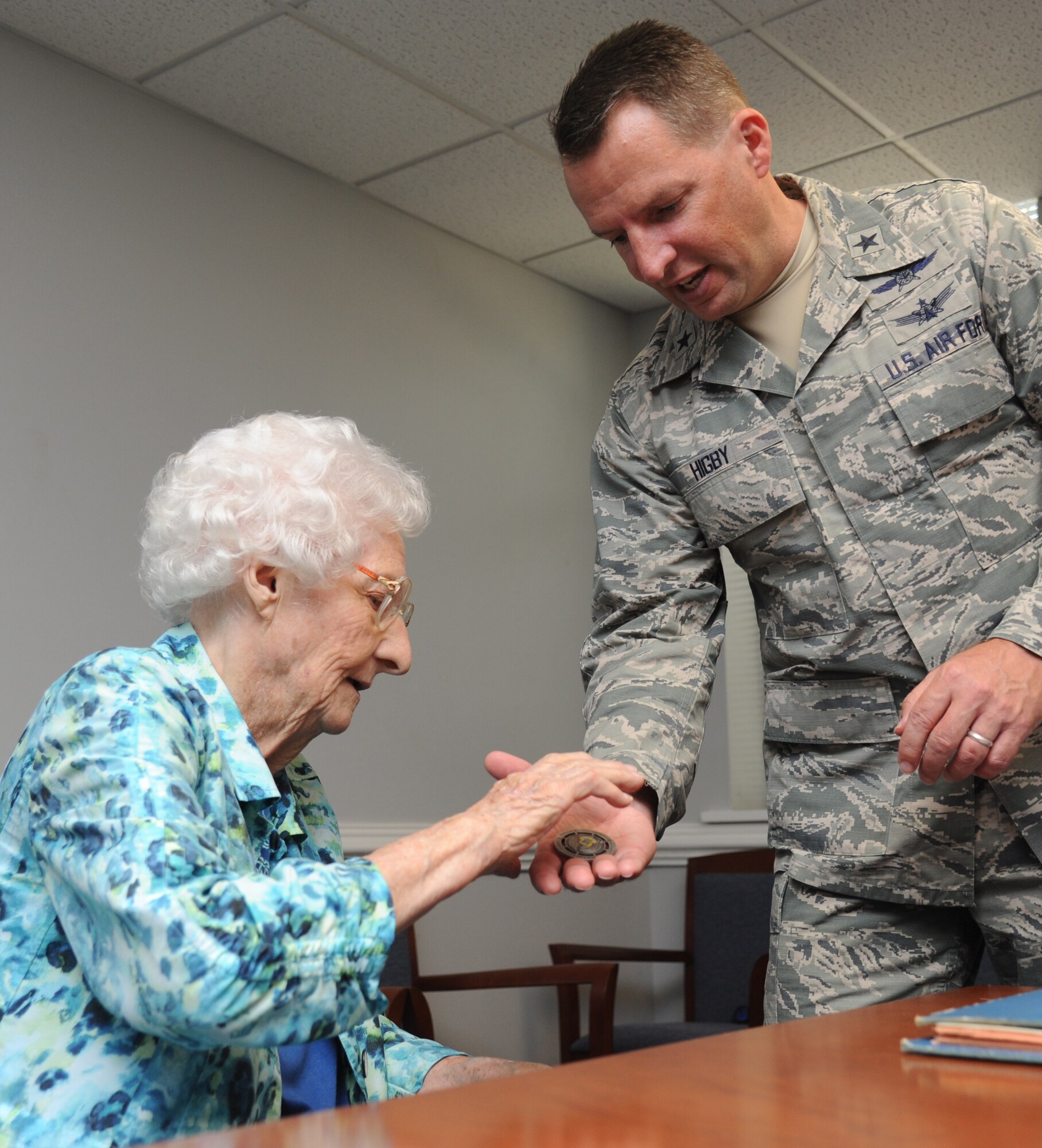 Brig. Gen. Patrick Higby, 81st Training Wing commander, presents a wing coin to Idella Urie of Biloxi during a Sept. 26 visit to Keesler Air Force Base, Mississippi.  Urie, who celebrates her 100th birthday Sept. 1, came to work at Keesler in 1942 to fabricate and replace plexiglass windshields and windows in aircraft during World War II and went on to develop plastic training aids.  She retired from federal employment at Keesler in 1973, more than 40 years ago. (U.S. Air Force photo by Kemberly Groue)