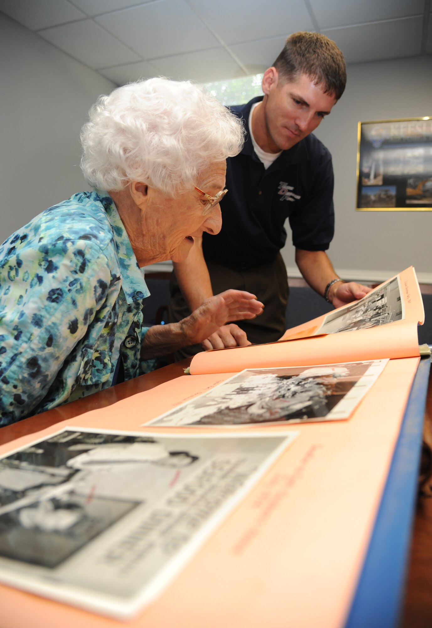 Idella Urie of Biloxi, who celebrates her 100th birthday Sept. 1, goes through a scrapbook with Tomme Lassabe, trainer development flight chief for the 81st Training Support Squadron, during a Sept. 26 visit to Keesler Air Force Base, Mississippi.  Urie came to work at Keesler in 1942 to fabricate and replace plexiglass windshields and windows in aircraft during World War II and went on to develop plastic training aids.  She retired from federal employment at Keesler in 1973, more than 40 years ago. (U.S. Air Force photo by Kemberly Groue)