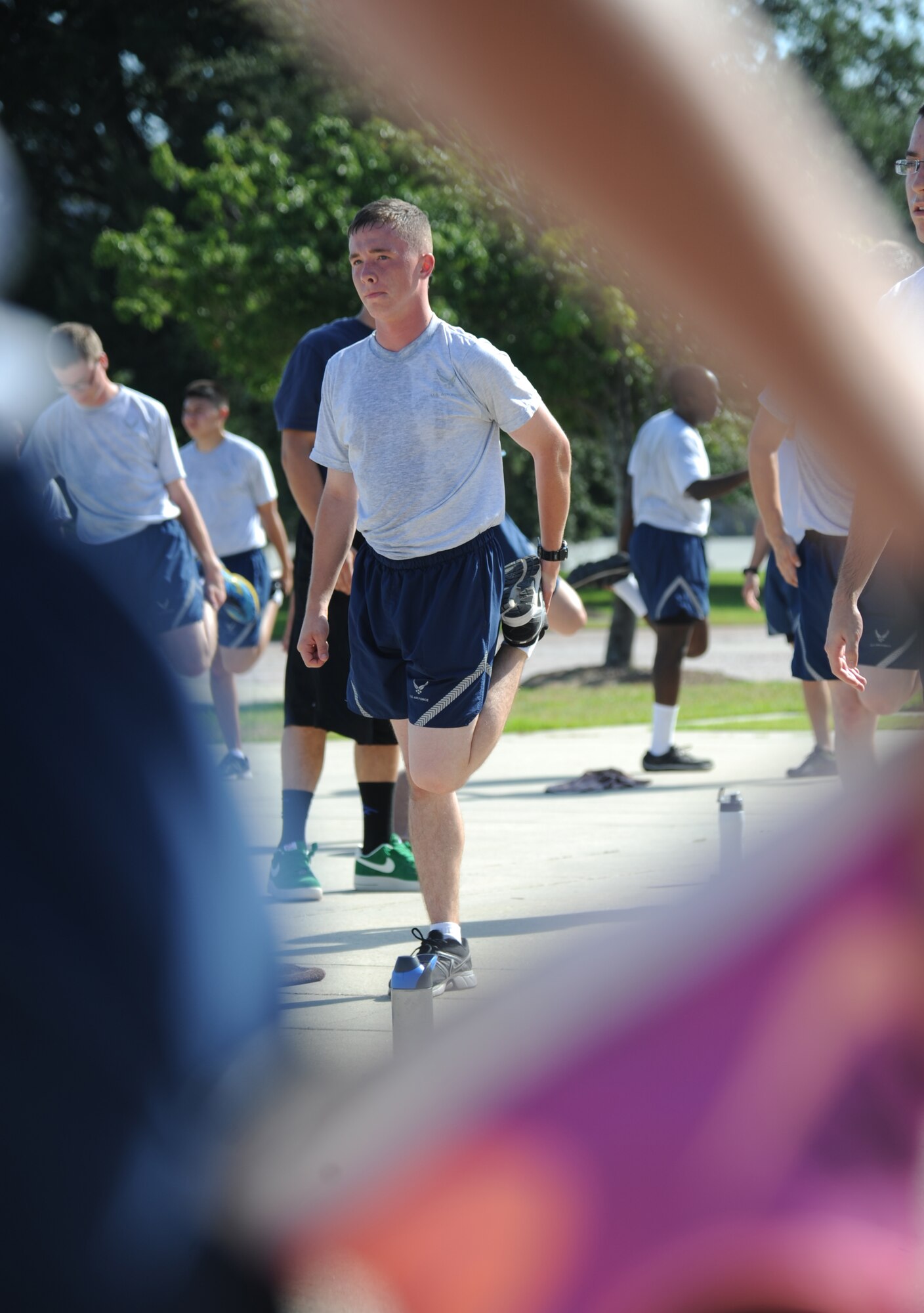 Airman 1st Class Steven Purkey, 338th Training Squadron, participates in cool down stretches during a physical training session Aug. 27, 2014, in the triangle area, Keesler Air Force Base, Miss.  Physical training is a top priority for Airmen to be prepared and equipped for any physical challenge they may face when conducting the mission at home station or in a deployed environment. (U.S. Air Force photo by Kemberly Groue)
