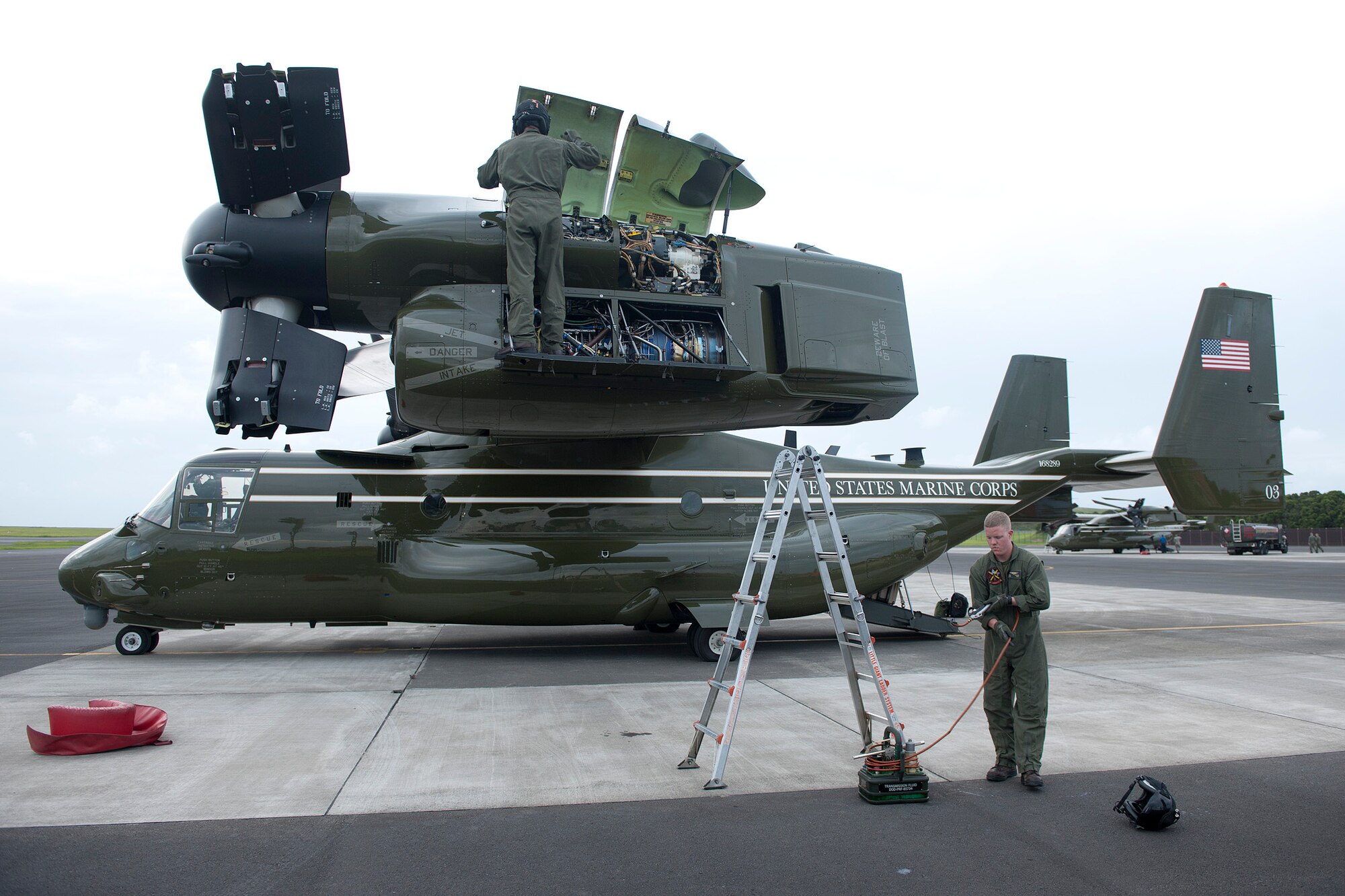 U.S. Marine Corps MV-22B Osprey crew chiefs perform post-flight inspections Aug. 26, 2014, Lajes Field, Azores, Portugal. The Marines are assigned to Marine Helicopter Squadron One, Marine Corps Base Quantico, Va. Marines assigned to HMX-1 provide Presidential and VIP support in addition to their primary role as the Operational Test and Evaluation unit for Marine assault support helicopters and related equipment. (U.S. Air Force photo by Tech. Sgt. Paul Villanueva II/Released)
