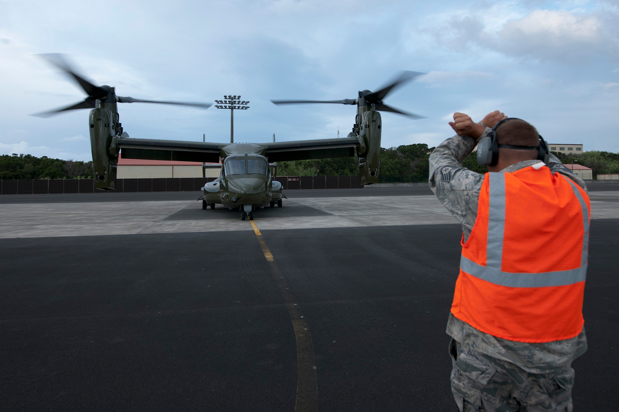 U.S. Air Force Staff Sgt.  Kyle Porter, 65th Operations Support Squadron coronet liaison and F-16 crew chief, marshals a U.S. Marine Corps MV-22B Osprey to a parking stall Aug. 26, 2014, Lajes Field, Azores, Portugal. The MV-22Bs are assigned to Marine Helicopter Squadron One, Marine Corps Base Quantico, Va. The MV-22Bs and Marines assigned to HMX-1 provide Presidential and VIP support in addition to their primary role as the Operational Test and Evaluation unit for Marine assault support helicopters and related equipment. (U.S. Air Force Photo by Tech. Sgt. Paul Villanueva II/Released)