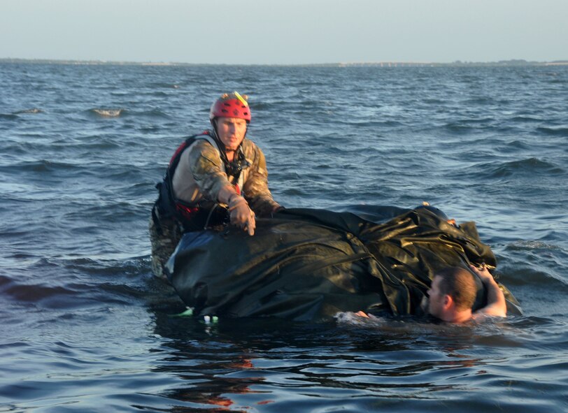 A pararescueman begins to deploy a rigging alternate method zodiac (RAMZ), a packaged cargo cube containing an inflatable, motorized Zodiac boat that is dropped from a plane, off the coast of Patrick Air Force Base, Fla, August 20. The RAMZ training is part of a rescue jumpmaster course being hosted by the 920th Rescue Wing, the Air Force Reserve’s only combat rescue unit. (U.S. Air Force photo/ Tech. Sgt. Katie Spencer) 