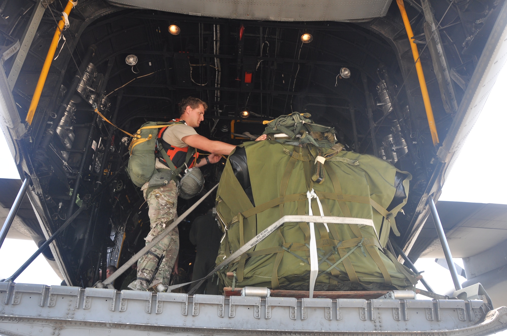 Senior Airman Jason Hughes, a pararescueman for the 306th Rescue Squadron, inspects a rigging alternate method zodiac (RAMZ), a packaged cargo cube containing an inflatable, motorized Zodiac boat that is dropped from a plane. The training is part of a rescue jumpmaster course being hosted by the 920th Rescue Wing, the Air Force Reserve’s only combat rescue unit. (U.S. Air Force photo/ Tech. Sgt. Katie Spencer)