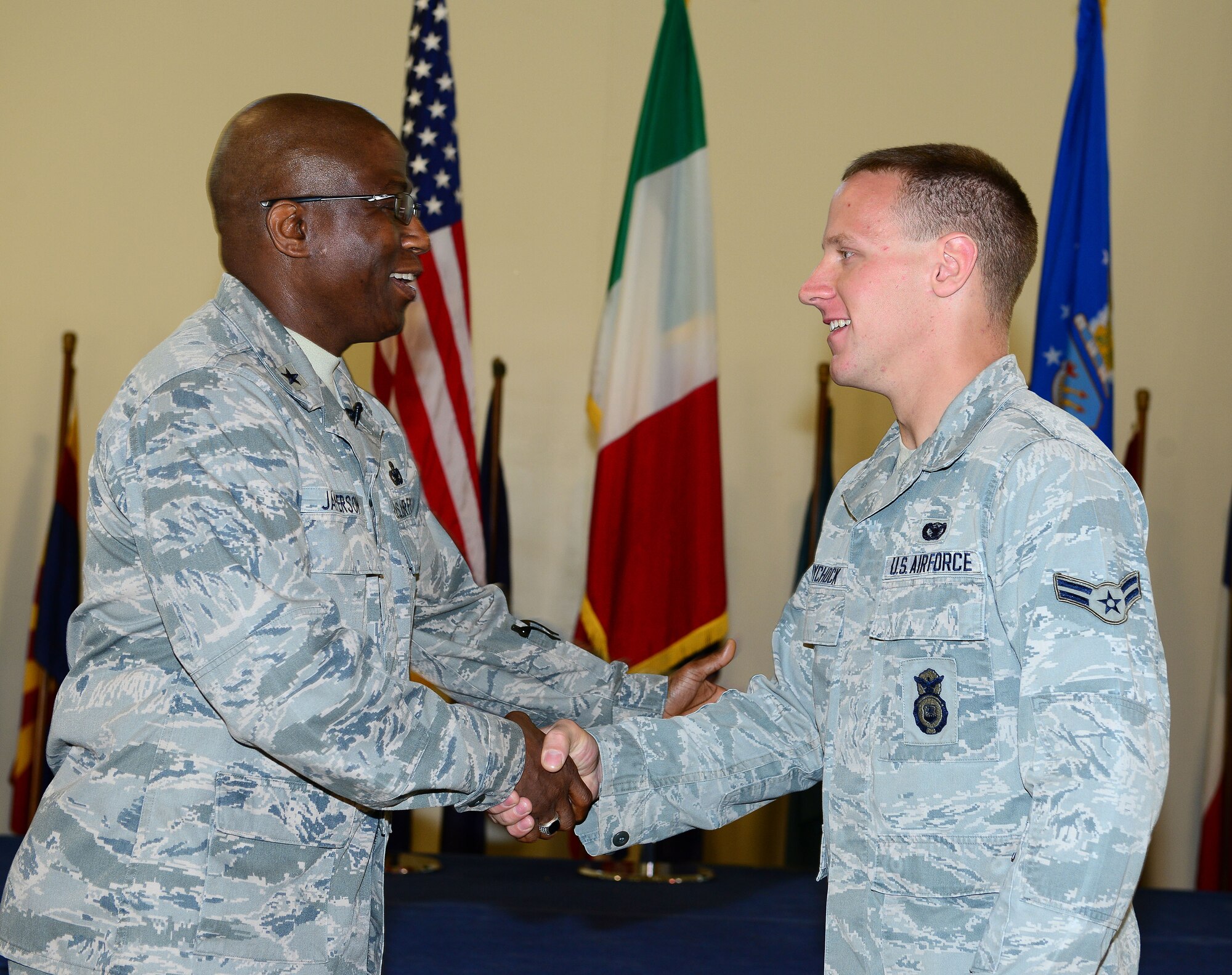 Brig. Gen. Allen Jamerson coins Airman 1st Class Michael Wychock, Aug. 29, 2014, at Aviano Air Base, Italy. During the all-call, Jamerson briefed the defenders about upcoming changes in the security forces career field and answered Airmen’s concerns about force management, future training requirements and law enforcement certifications. Jamerson is the Director of Security Forces, Deputy Chief of Staff for Logistics, Installations and Mission Support, Headquarters U.S. Air Force, Washington, D.C. and Wychock is a 31st Security Forces Squadron member. (U.S. Air Force photo/Senior Airman Matthew Lotz)
