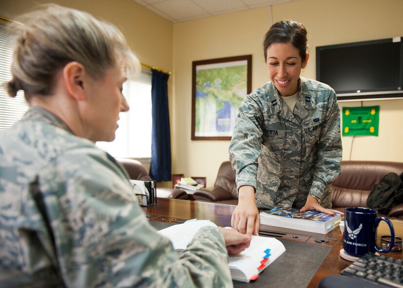 U.S. Air Force Capt. Sarah Huerta, 379th Air Expeditionary Wing chief of military justice, advises Col. Caroline Miller, 379th Expeditionary Mission Support Group commander on Uniform Code of Military Justice at Al Udeid Air Base, Qatar, Aug 25, 2014.  JAG officers routinely participate in nearly every facet of the Air Force mission including developing and acquiring weapons systems, ensuring availability of airspace and ranges where those systems are tested and operated, consulting with commanders about how those systems are employed in armed conflict, and assisting commanders in the day-to-day running of military installations around the world. (U.S. Air Force photo by Senior Airman Colin Cates) 