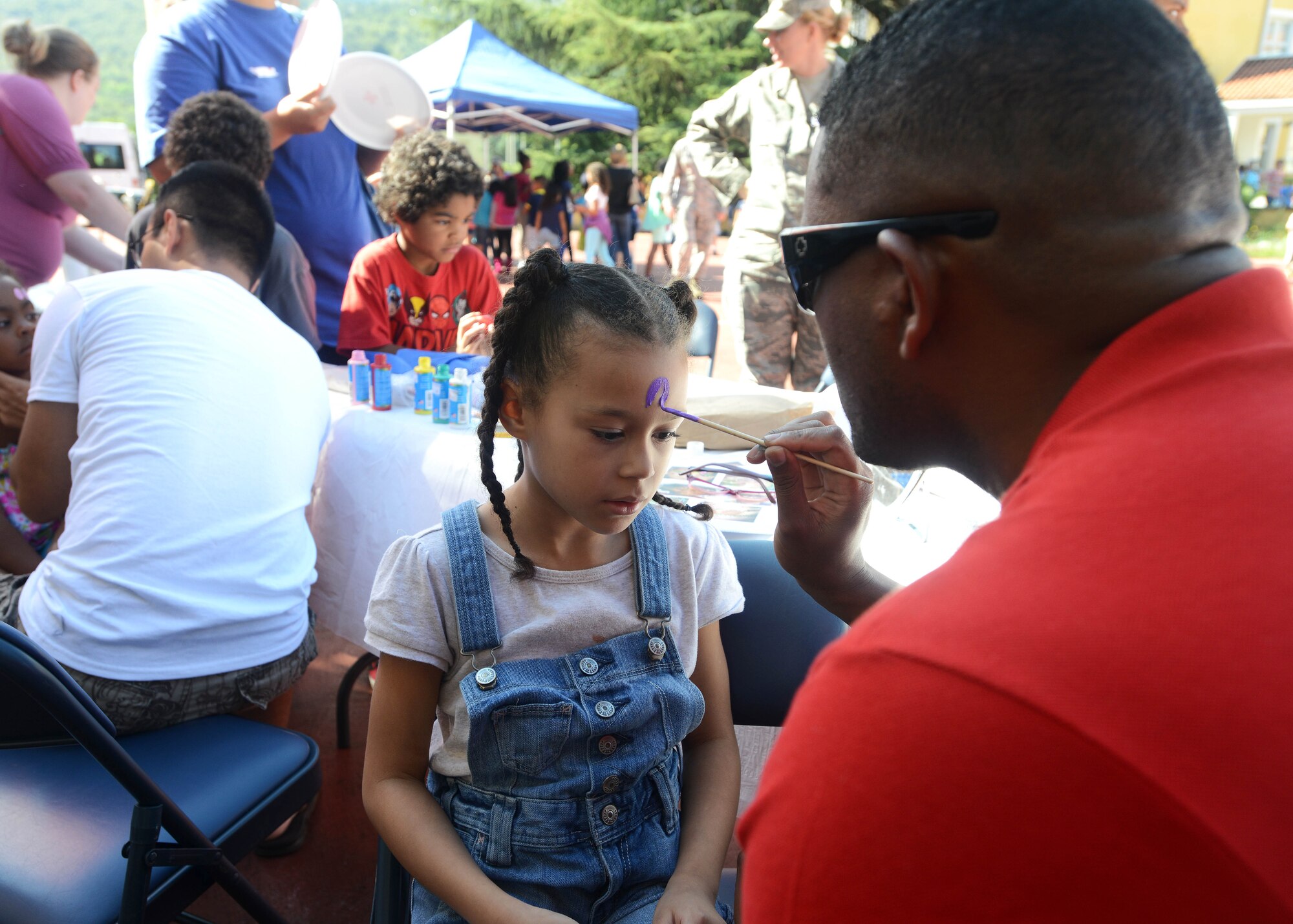 Kyla Wilbert, daughter of Senior Airman Keylon Wilbert, gets her face painted during the “Back to School Bash,” Aug. 28, 2014, at Aviano Air Base, Italy. After parents met with teachers guests enjoyed concessions and games during a cookout on the school grounds. (U.S. Air Force photo/Airman 1st Class Deana Heitzman)