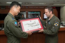 Members from the Republic of Korea Air Force 120th Fighter Squadron and U.S. Air Force 35th Fighter Squadron exchange mementos during Exercise Buddy Wing 14-8 at Seosan Air Base, ROK, Aug. 21, 2014. This exercise provided ROKAF and Wolf Pack fighter pilots an opportunity to exchange ideas, experience cultural differences, discuss and practice combined tactics, as well as plan, brief, fly and debrief missions together. (U.S. Air Force photo by Senior Airman Taylor Curry/Released)