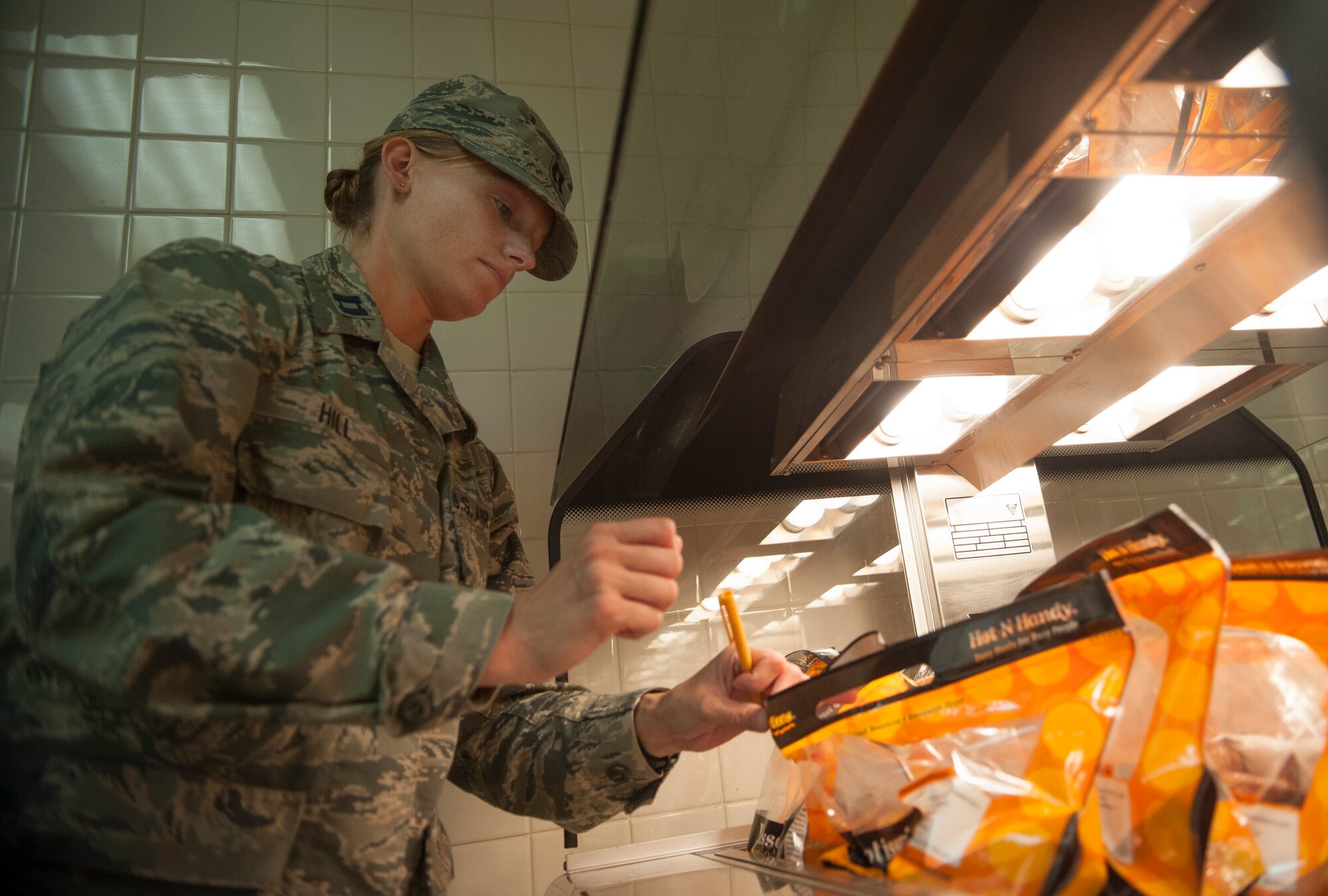 Capt. Sarah Hill, 51 Aerospace Medicine Squadron chief of public health operations, checks the internal temperature of chicken at Osan Air Base, Republic of Korea, Aug. 17, 2014. Public health makes sure that food facilities on base are following the proper U.S. food regulations. (U.S. Air Force photo by Senior Airman Matthew Lancaster/Released)