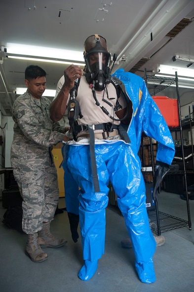 Staff Sgt. Paolo Melaendez, 51st Aerospace Medicine Squadron bioenvironmental technician, helps Tech. Sgt. Shane Polk, 51st AMDS bioenvironmental technician, put on a Level A hazardous material suit at Osan Air Base, Republic of Korea, Aug. 27, 2014. The Level A suit is the highest level hazmat protection suit against vapors, gases, mists and particles. It consists of a fully encapsulating chemical entry suit with a full-face piece self-contained breathing apparatus or a supplied air respirator with an escape cylinder. (U.S. Air Force photo by Senior Airman Matthew Lancaster/Released)