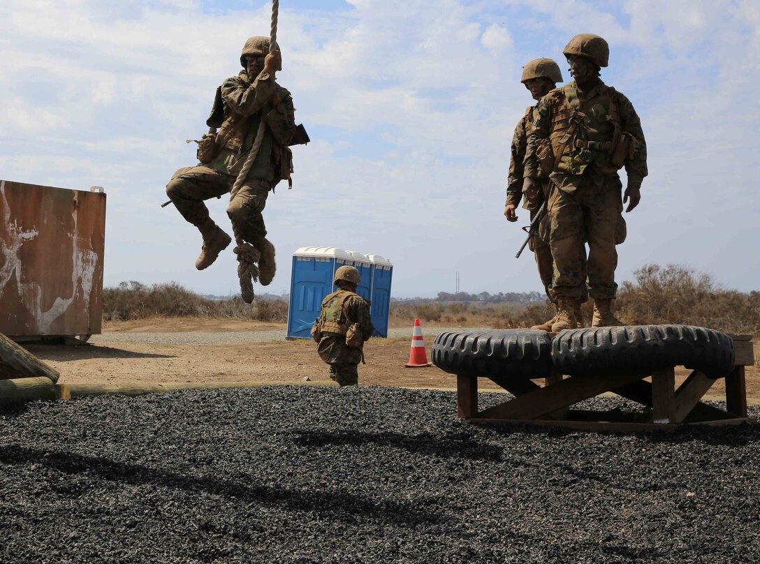 Pvt. Joel A. Lopez swings from one platform to another on Gonzalez’s Challenge during the Crucible.