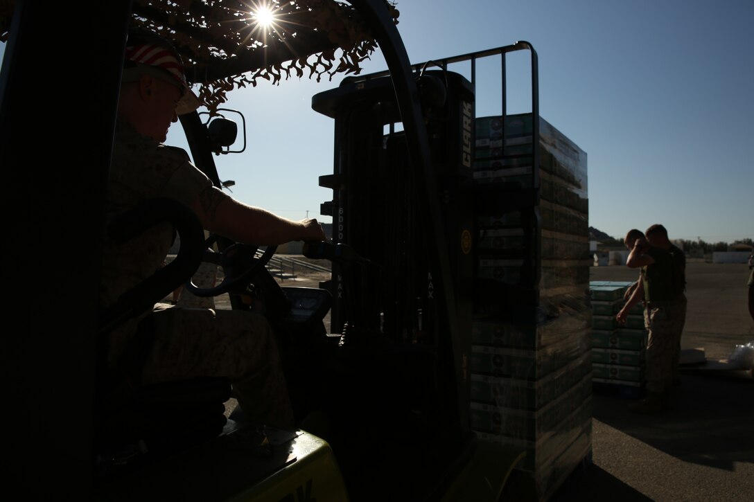 Cpl. Robert Irwin, packing specialist, Distribution Management Office, unloads a double stack of coffee at a loading dock for Operation Coffee Giveaway with donated Keurig cups and ground coffee from Holy Joe’s Café, Aug. 21, 2014.