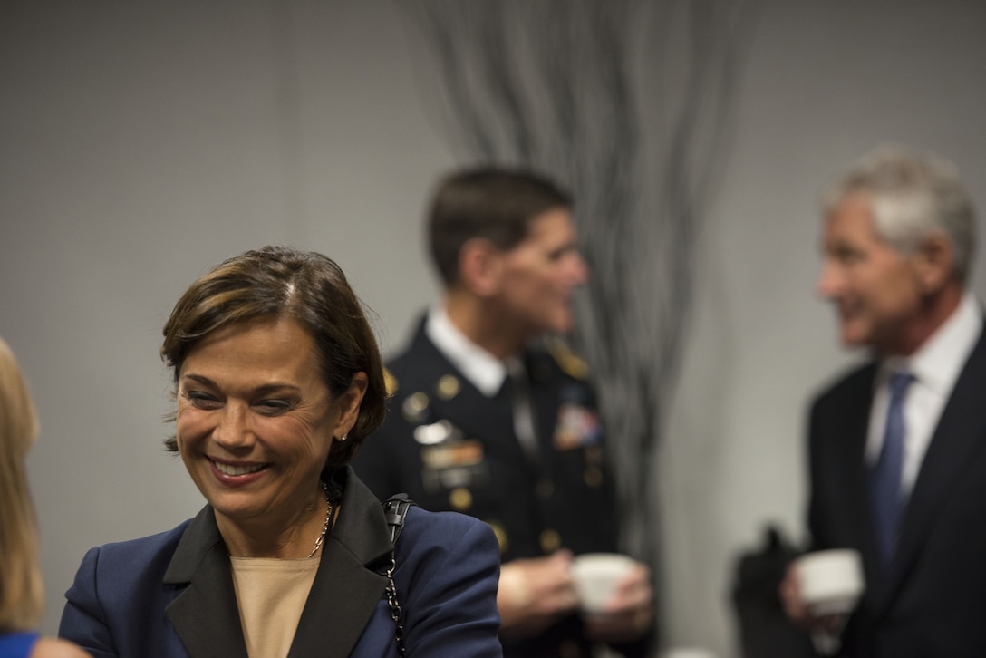 Lilibet Hagel, wife of Defense Secretary Chuck Hagel, shares a light moment with Deanie Dempsey, left foreground, wife of Army Gen. Martin E. Dempsey, chairman of the Joint Chiefs of Staff, before the change-of-command ceremony for U.S. Special Operations Command in Tampa, Fla., Aug. 28, 2014. 
