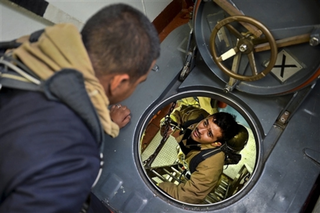 U.S. Navy Seaman Marten Palomo, right, relays a message to Petty Officer 2nd Class Julius Gomez during an engineering casualty drill on the guided-missile frigate USS Rodney M. Davis in the Philippine Sea, Aug. 28, 2014. The frigate is patrolling in the U.S. 7th Fleet area of responsibility to support security and stability in the Indo-Asia-Pacific region. 