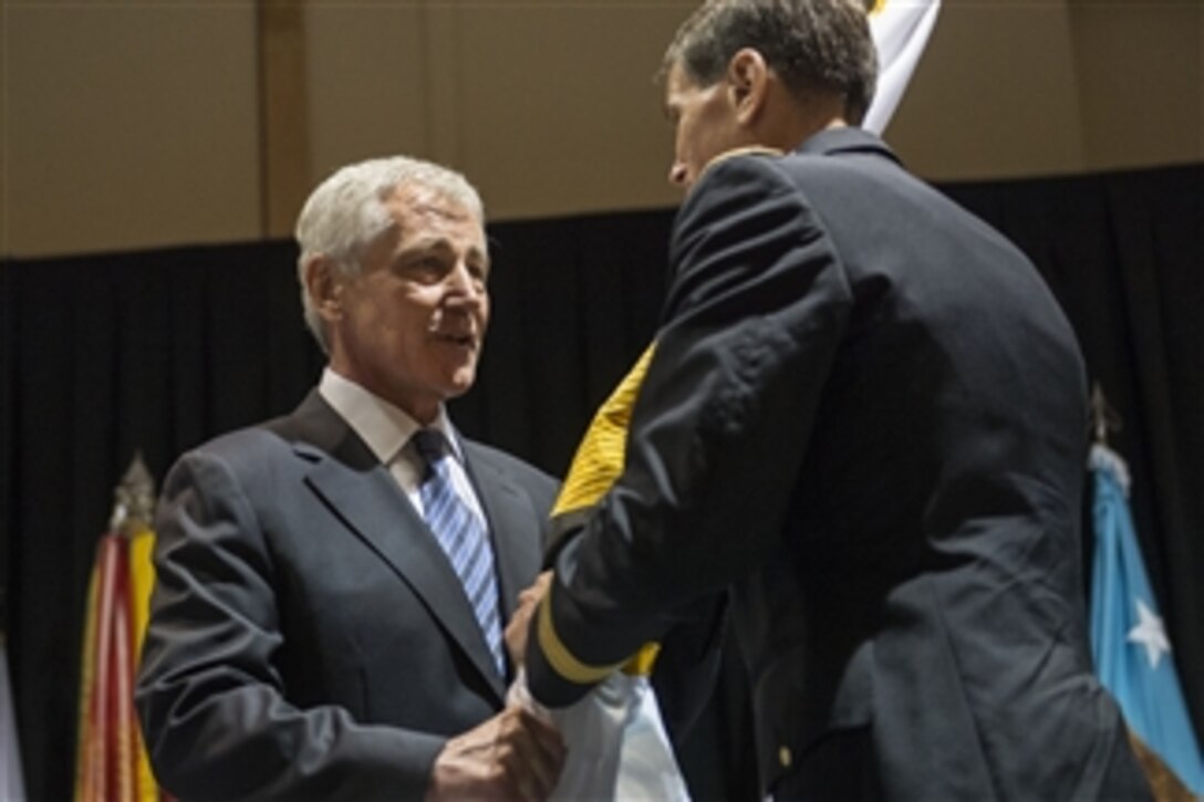 Defense Secretary Chuck Hagel, left, passes the U.S. Special Operations Command flag to incoming commander Army Gen. Joseph L. Votel III during a change-of-command ceremony in Tampa, Fla., Aug. 28, 2014. Votel assumed command from Navy Adm. William H. McRaven. 