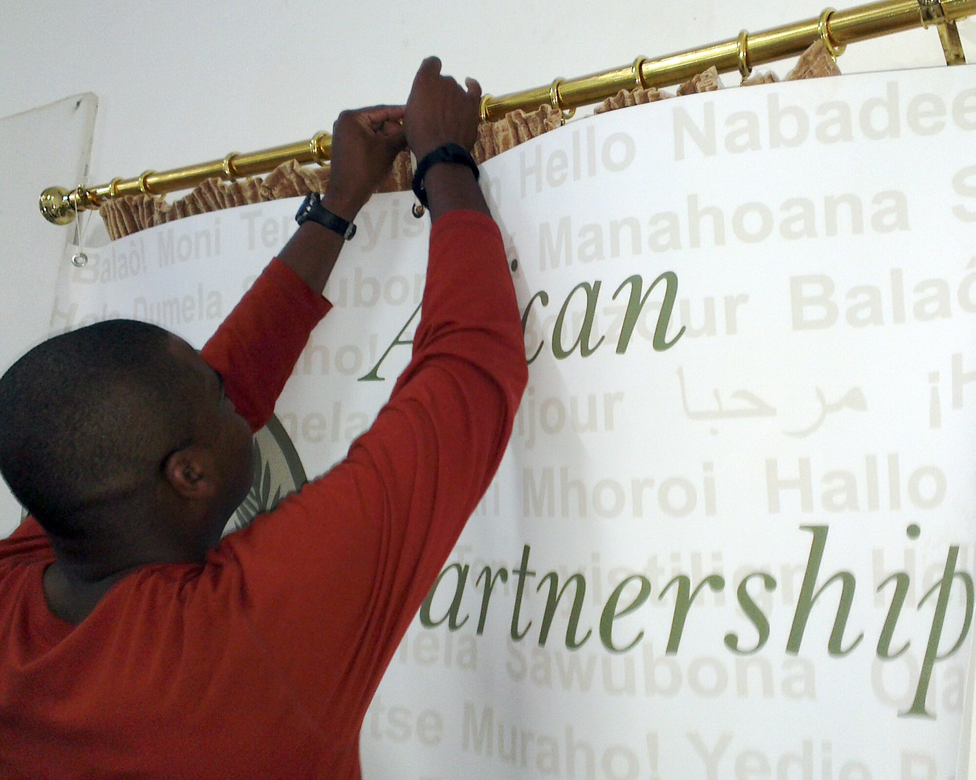 U.S. Air Force Master Sgt. Jerome Williams, ground safety instructor from the 818th Mobility Support Advisory Squadron, Joint Base McGuire-Dix-Lakehurst, N.J., hangs up an African Partnership Flight Mauritania banner Aug. 30, 2014, in his classroom prior to students arriving the next day. Airmen from six African nations will arrive to Atar Air Base in Mauritania to take part in the third APF for this year. This APF is scheduled to teach students ground and flight safety, as well as, Intelligence Surveillance Reconnaissance, and command operations with a primary goal to help partner nations fight terrorism in the region. (U.S. Air Force photo/Master Sgt. Brian Boisvert/Released)