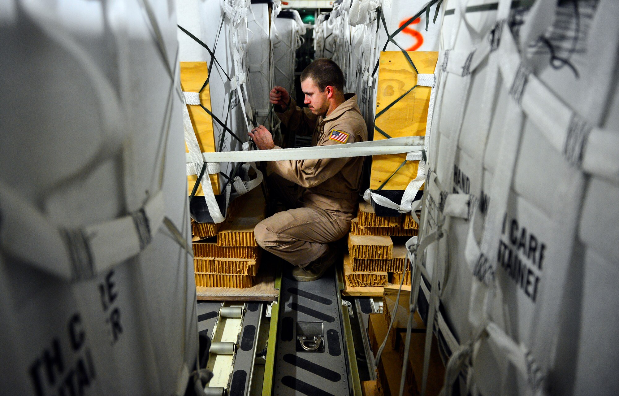 Staff Sgt. Justin Wright, 816th Expeditionary Airlift Squadron, C-17 Globemaster III loadmaster, performs a joint airdrop inspection to ensure the safe offload prior to a humanitarian airdrop mission over Amirli, Iraq, Aug. 30, 2014. The two C-17s dropped 79 container delivery system bundles of fresh drinking water totaling 7,513 gallons. (U.S. Air Force photo by Staff Sgt. Vernon Young Jr.)