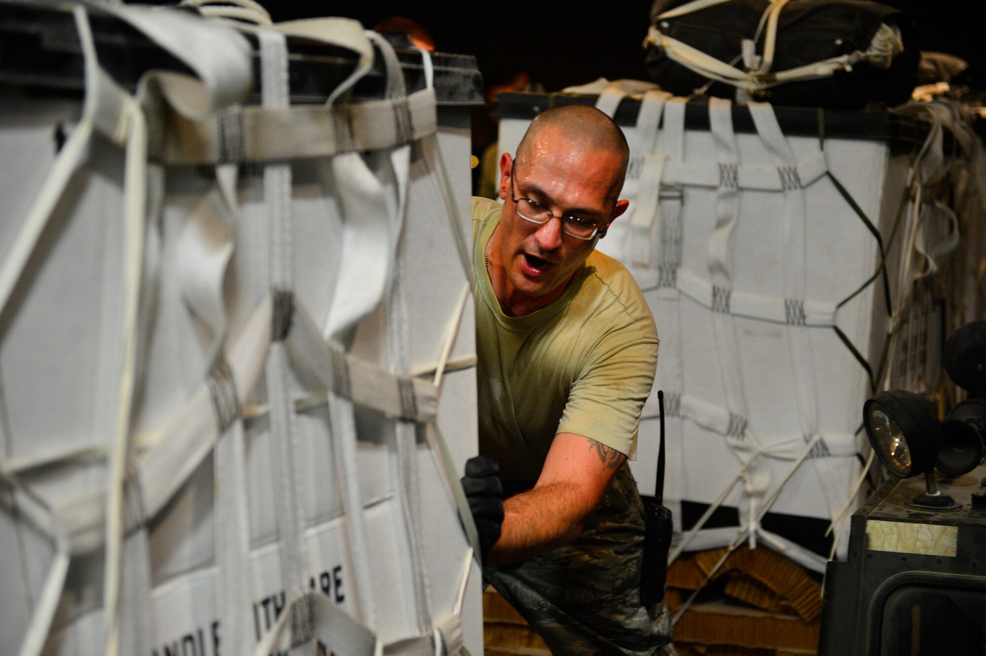 Tech. Sgt. Matthew Kadish, 8th Expeditionary Air Mobility Squadron ramp supervisor, pushes a water bundle onto a C-17 Globemaster III in support of a humanitarian airdrop mission over Amirli, Iraq, Aug. 30, 2014. The two C-17s dropped 79 container delivery system bundles of fresh drinking water totaling 7,513 gallons. In addition, the two U.S. C-130s aircraft dropped 30 bundles totaling 3,032 gallons of fresh drinking water and 7,056 meals ready to eat. (U.S. Air Force photo by Staff Sgt. Vernon Young Jr.)