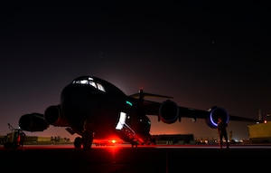 Senior Airman Jon Woerzburger, 816th Expeditionary Airlift Squadron, C-17 Globemaster III flying crew chief, awaits engine start prior to a humanitarian airdrop mission over Amirli, Iraq, Aug. 30, 2014. The two C-17s dropped 79 container delivery system bundles of fresh drinking water totaling 7,513 gallons. In addition, the two U.S. C-130s aircraft dropped 30 bundles totaling 3,032 gallons of fresh drinking water and 7,056 meals ready to eat. (U.S. Air Force photo by Staff Sgt. Vernon Young Jr.)