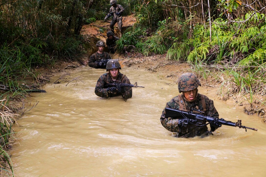Marines go through the Jungle Warfare Training Center’s endurance course Nov. 25 on Camp Gonsalves. During the course, the Marines had to make their way through pits filled with muddy water and many other obstacles. “The hardest part of the course was the stretcher carry,” said Cpl. Samuel C. Mills from Lawrenceville, Georgia. “Trying to get the stretcher, with the Marine on it, over the hills was miserable.” Mills is a fire support man with 1st Battalion, 1st Marine Regiment, currently assigned to 4th Marine Regiment, 3rd Marine Division, III Marine Expeditionary Force, under the unit deployment program. 