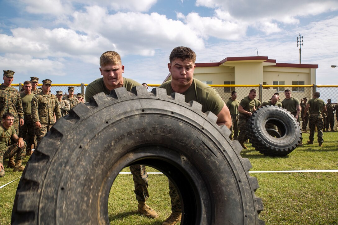Pfc. Joshua Facenbaker, right, flips a 7-ton truck tire with Lance Cpl. Colin Osler Nov.14 during the Shanghai Commanders’ Cup at Camp Schwab. The Shanghai Cup pitted three unit deployment program battalions and Headquarters Company, 4th Marine Regiment, against each other in nine events. October marked the first year that 4th Marines has had three full battalions under its command since its reactivation in 1951. Facenbaker, from Malvern, Ohio, is a rifleman with 2nd Battalion, 9th Marine Regiment, currently assigned to 4th Marine Regiment, 3rd Marine Division, III Marine Expeditionary Force, under the unit deployment program. Osler, from Marlton, New Jersey, is a machine-gunner with 2nd Bn. 