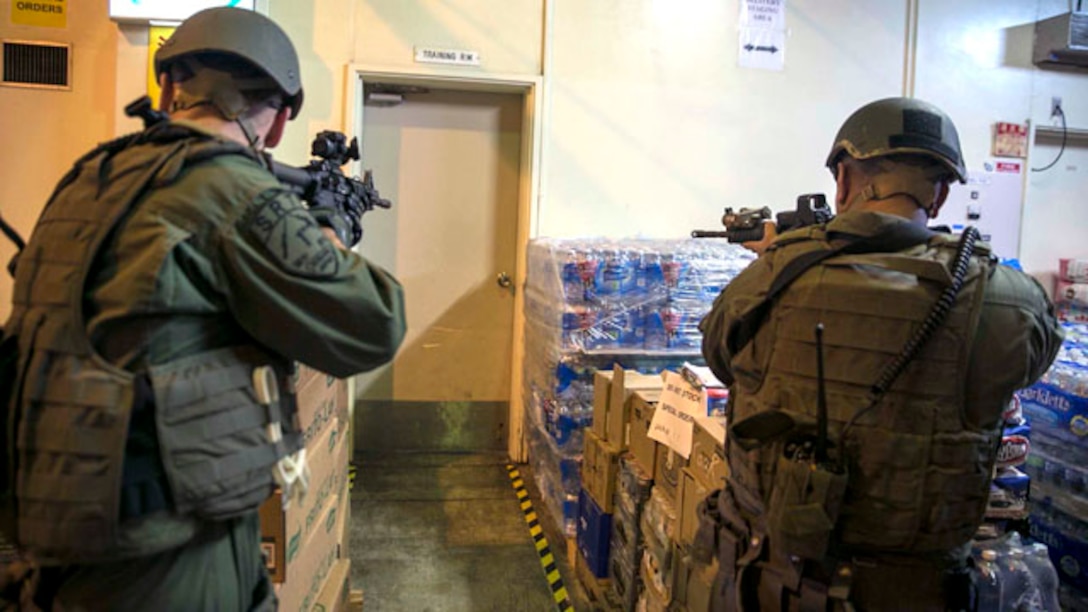 Military policemen approach a barricaded suspect during an active shooter reaction drill Nov. 20 at Camp Courtney’s Commissary. The military policemen had the opportunity to use the exchange and the commissary to train in a setting where they could potentially to operate. The Marines are with the Special Reaction Team, Provost Marshal’s Office, Marine Corps Base Camp Smedley D. Butler, Marine Corps Installations Pacific. (U.S. Marine Corps photo by Lance Cpl. Isaac Ibarra/Released)
