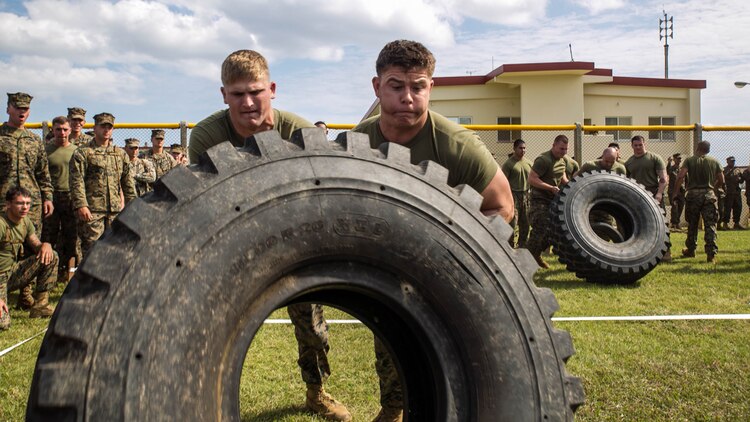 Pfc. Joshua Facenbaker, right, flips a 7-ton truck tire with Lance Cpl. Colin Osler Nov.14 during the Shanghai Commanders’ Cup at Camp Schwab. The Shanghai Cup pitted three unit deployment program battalions and Headquarters Company, 4th Marine Regiment, against each other in nine events. October marked the first year that 4th Marines has had three full battalions under its command since its reactivation in 1951. Facenbaker, from Malvern, Ohio, is a rifleman with 2nd Battalion, 9th Marine Regiment, currently assigned to 4th Marine Regiment, 3rd Marine Division, III Marine Expeditionary Force, under the unit deployment program. Osler, from Marlton, New Jersey, is a machine-gunner with 2nd Bn. 